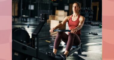 fit, focused brunette woman using a rowing machine at the gym