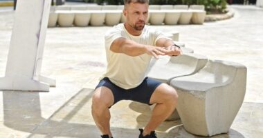 fit man doing squats, concept of challenging workouts to increase gains