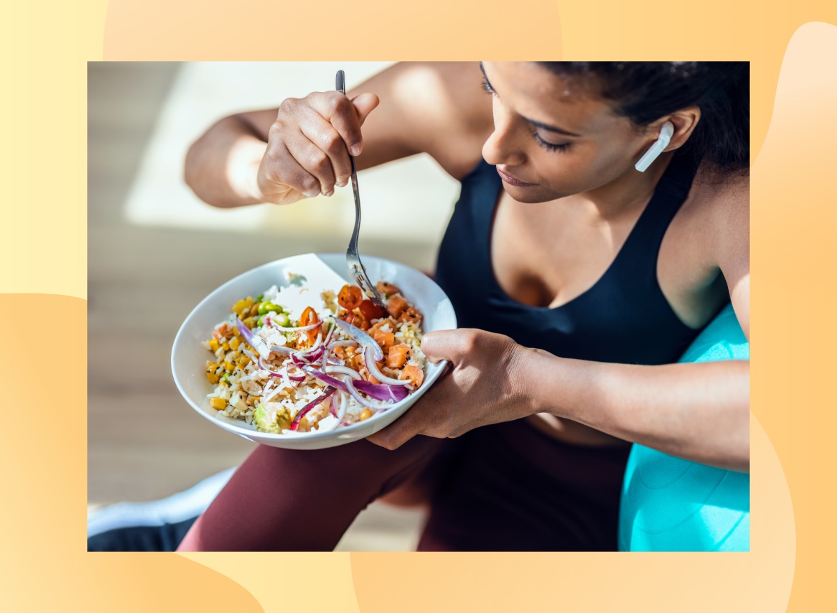 close-up of fitness woman eating healthy lunch while sitting next to exercise ball in bright living space