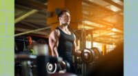 fit, muscular man lifting dumbbells at the gym