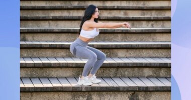 fit, focused brunette woman doing squats on stairs outdoors