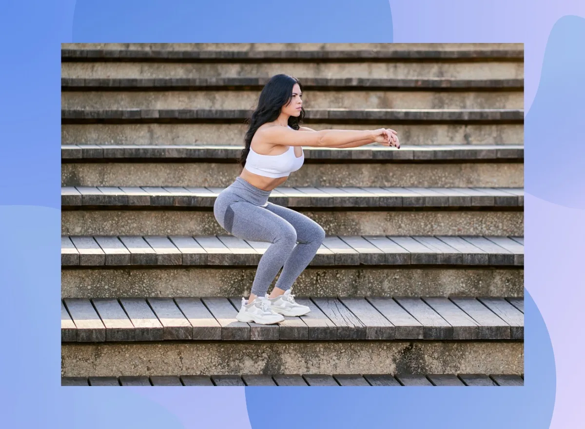 fit, focused brunette woman doing squats on stairs outdoors