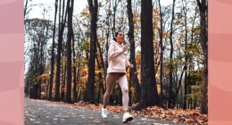 brunette woman running outdoors on trail in the fall with leaves on the ground