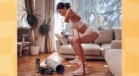 fit, determined brunette woman doing resistance band squats in bright living room