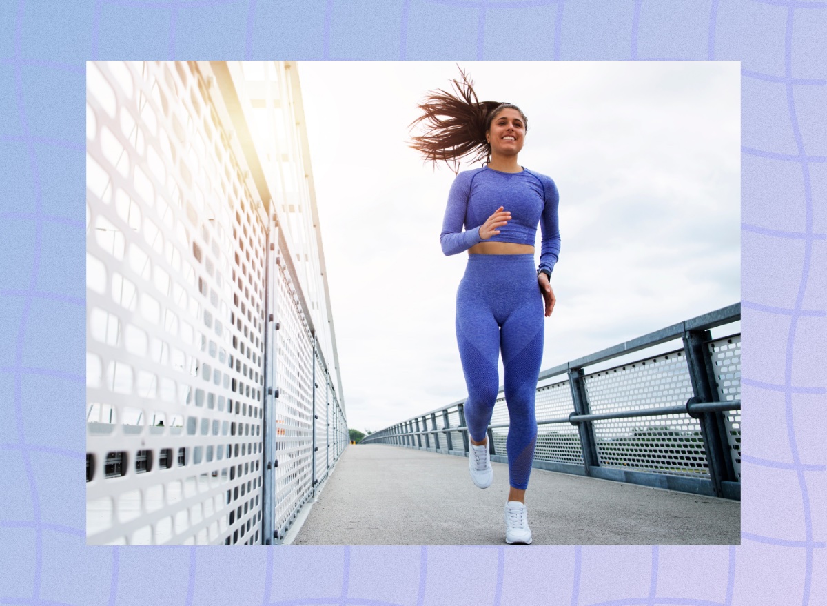 fit brunette woman running outdoors on bridge on fall or winter day