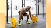 fit man doing a barbell deadlift at the gym