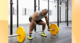 fit man doing a barbell deadlift at the gym