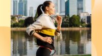 fit brunette woman jogging along river in the city