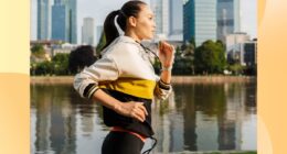 fit brunette woman jogging along river in the city