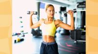 fit blonde woman exercising with dumbbells at the gym