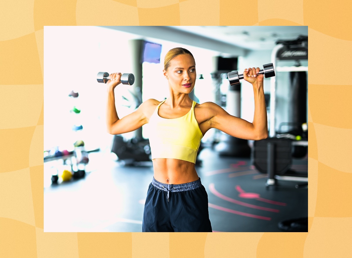 fit blonde woman exercising with dumbbells at the gym