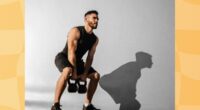 focused, muscular man doing kettlebell squat