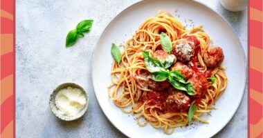 a plate of spaghetti and meatballs on a designed background