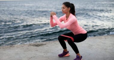 fitness woman doing banded squats, concept of resistance band exercises to burn body fat