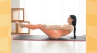 focused woman doing v-up exercise on yoga mat at home