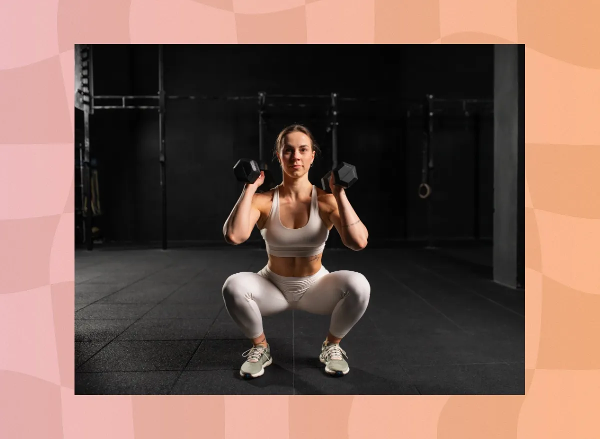 fit, focused woman doing squat to press exercise in dark gym