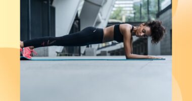 fit woman doing forearm plank on exercise mat outdoors