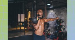 fit, shirtless man doing kettlebell exercises in dark gym setting