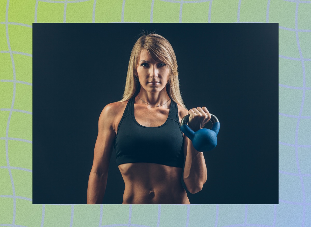 fit blonde woman holding kettlebell in front of black backdrop