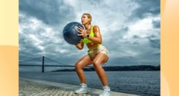 fit woman holding medicine ball while squatting