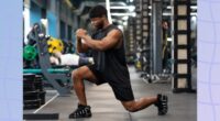 fit, muscular man doing lunges at the gym