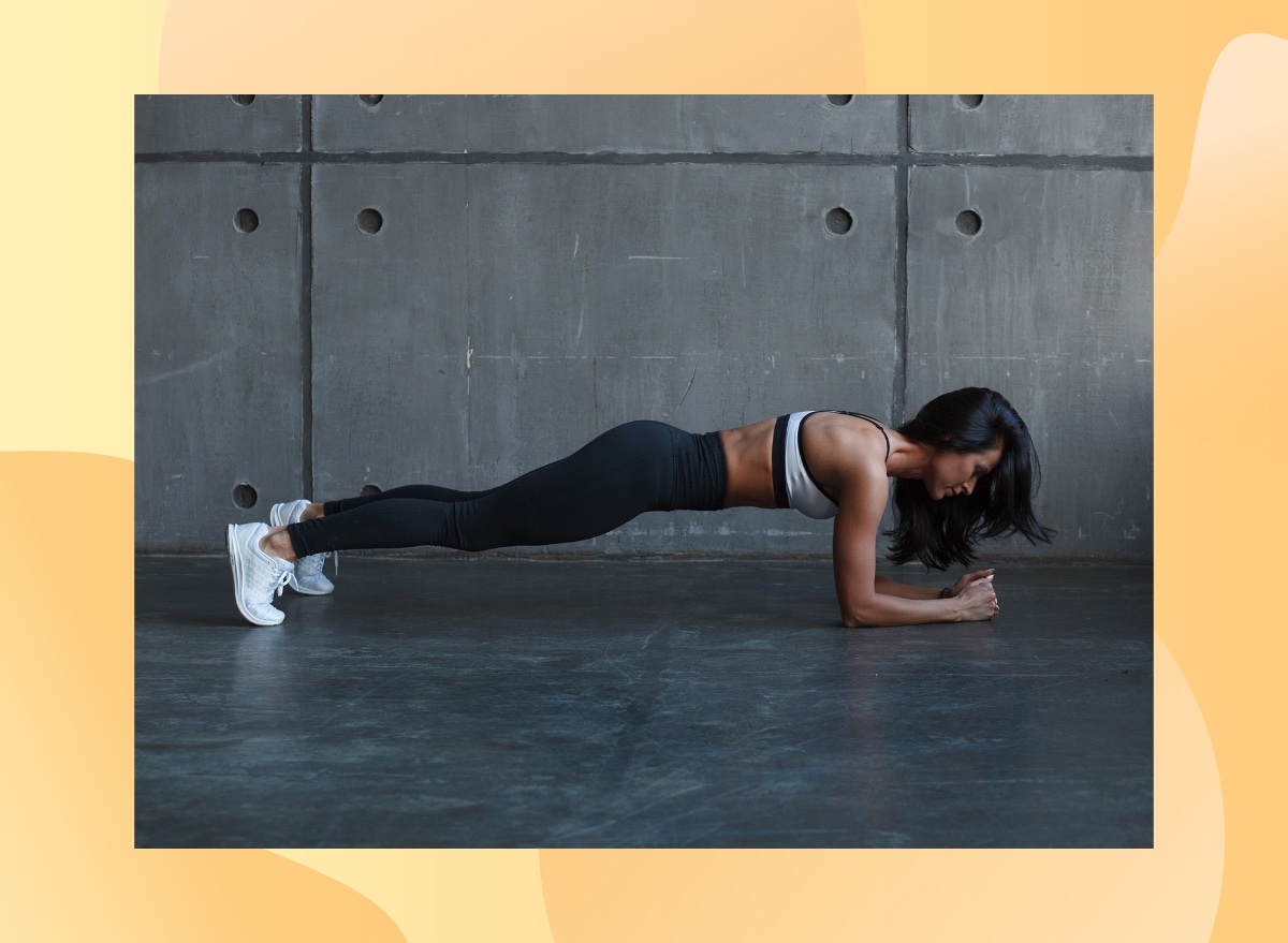 fit brunette woman holding a forearm plank