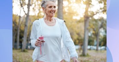 mature, happy woman walking outdoors in the park on fall day