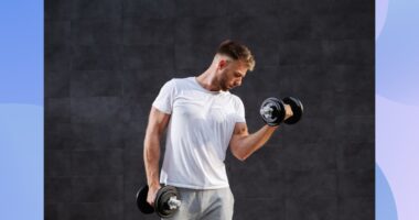 fit man lifting dumbbells in front of black backdrop