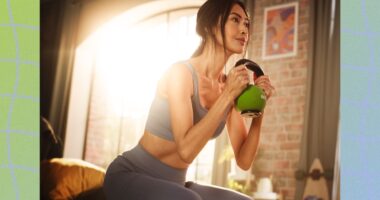 fit woman doing kettlebell goblet squat in bedroom