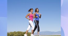 two fit women walking for exercise through scenic field trail