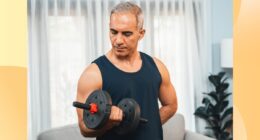 fit, mature man doing bicep curl in living space in front of couch and curtains