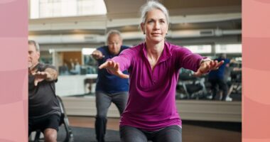 fit, mature woman doing squats in group fitness class at the gym