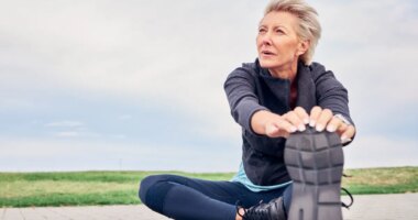 mature woman stretching, cooling down after run