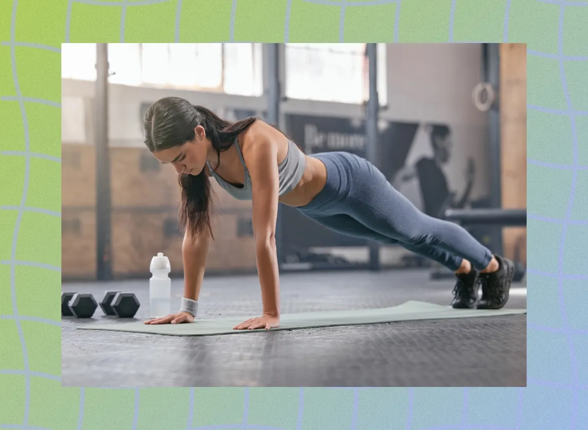 fit brunette woman holding high plank exercise on yoga mat at the gym