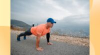 fit, mature man doing high plank or pushups on side of the road with mountains in the background