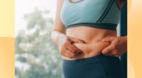 close-up of woman in athletic outfit holding excess belly fat