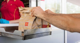 McDonalds service the Drive-Thru due to coronavirus. Employee in gloves, order in window. Contactless transfer.