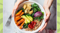 woman holding bowl of vegetables sweet potatoes avocado tofu hemp seeds onion kale grains