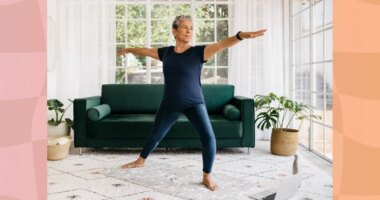 mature woman doing a balance yoga exercise in bright living room