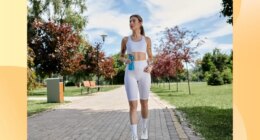 fit woman walking outdoors for exercise on sunny day along path in park