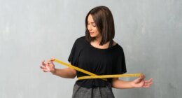 Young sport woman with tape measure