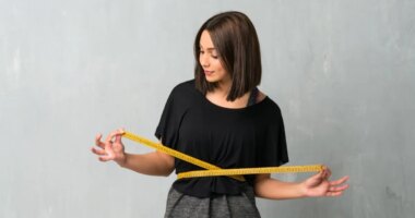 Young sport woman with tape measure