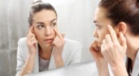 Woman checking wrinkles in front of the mirror.