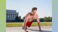 fit, shirtless man doing high plank exercise, gearing up for burpees outdoors on sidewalk