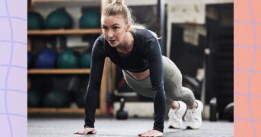 focused blonde woman doing high plank or pushup at the gym