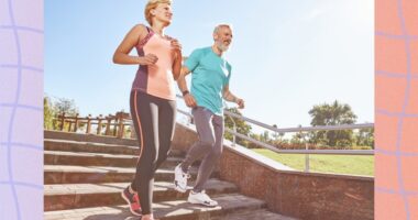 fit, mature couple running outdoors down stairs for exercise on sunny summer day