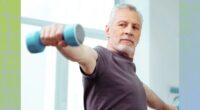 fit, mature man focused while doing a dumbbell lateral raise exercise