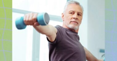 fit, mature man focused while doing a dumbbell lateral raise exercise