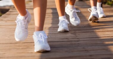 group of people walking on beach for exercising in the morning