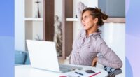 woman stretching and experiencing back pain while seated at her desk